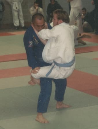 Alt Two fighters mid-match, one jumping into guard